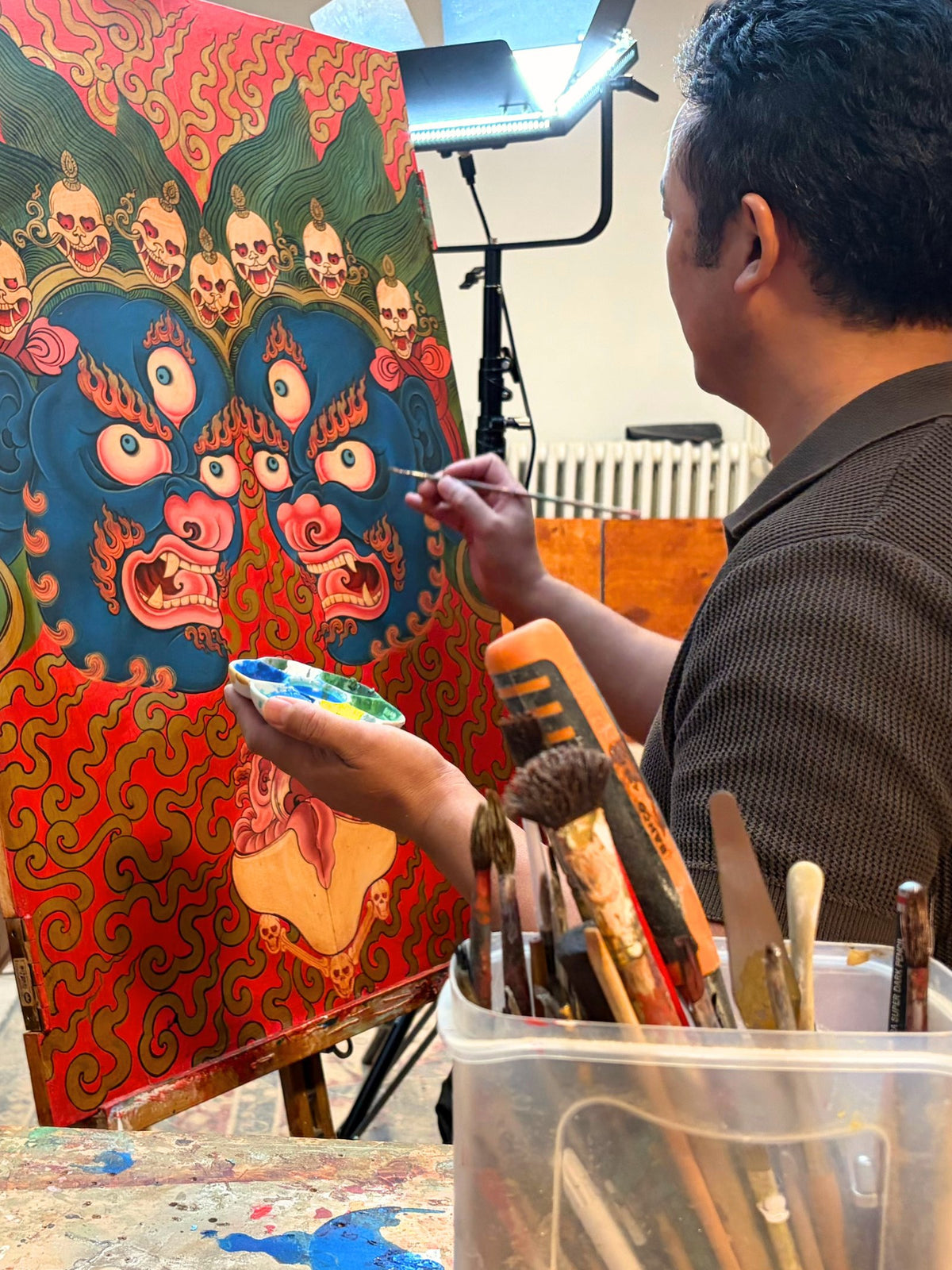 Jamyang bemalt eine Schranktür im Atelier Tibet